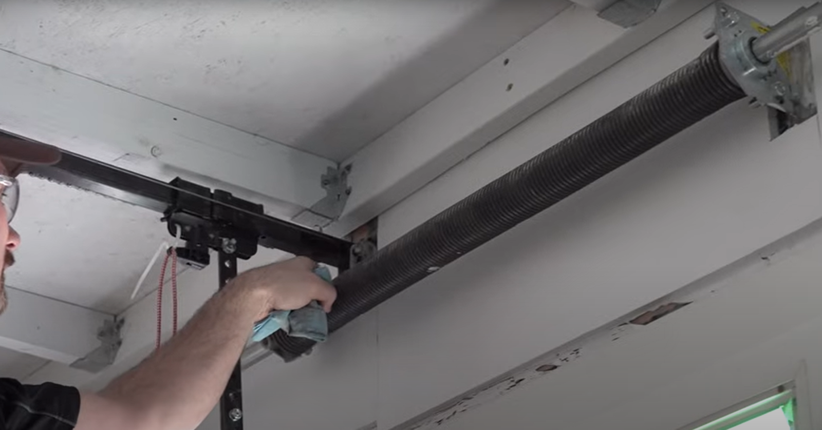 Professional technician performing garage door spring repair in Baltimore OH, showcasing expertise and precision with specialized tools."