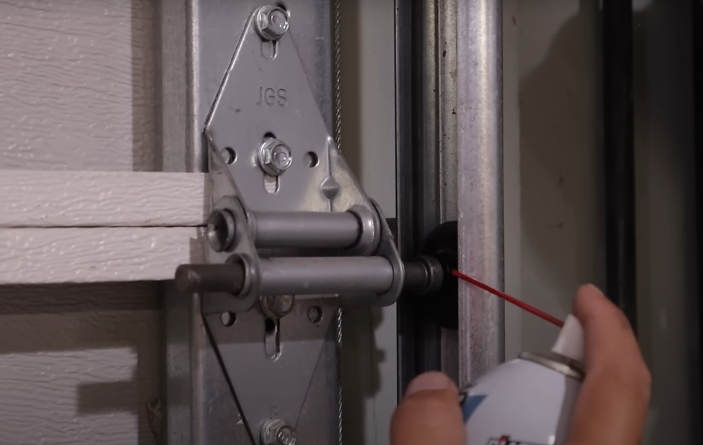 Professional technician repairing a noisy garage door in Baltimore, OH, focusing on the mechanism and tools used for fixing the issue.