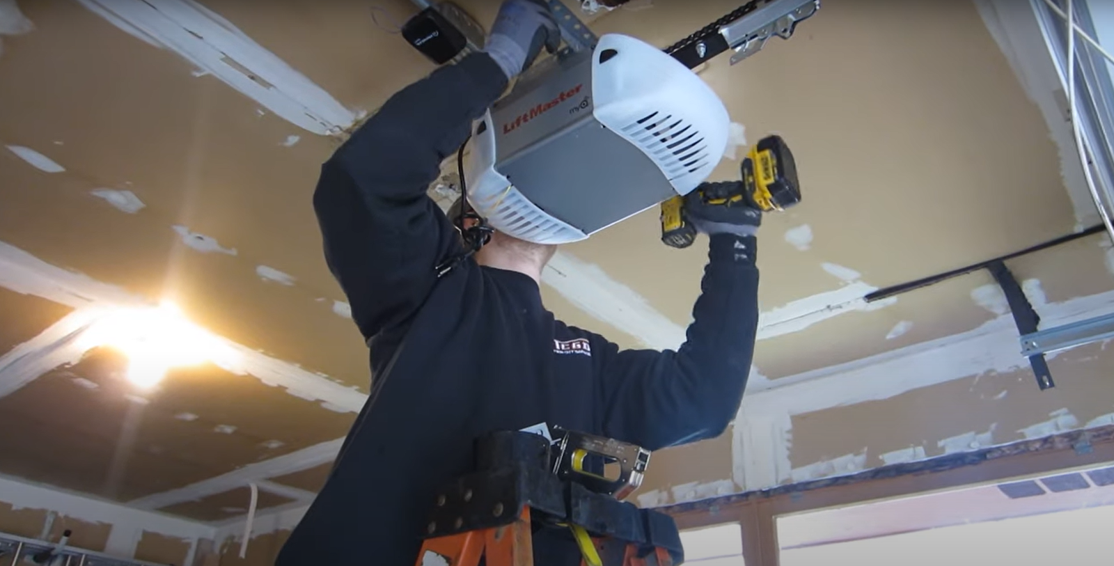 Professional technician repairing a garage door opener mechanism with specialized tools and equipment, highlighting garage door opener repair services in Johnstown, Ohio.
