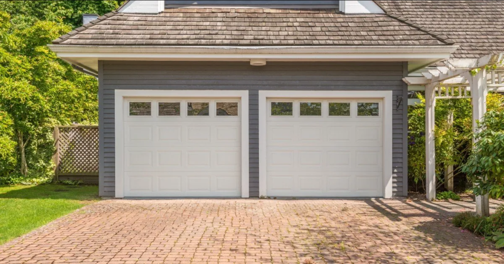 Professional technician in uniform repairing a garage door with tools in hand, highlighting efficient same-day garage door repair service.