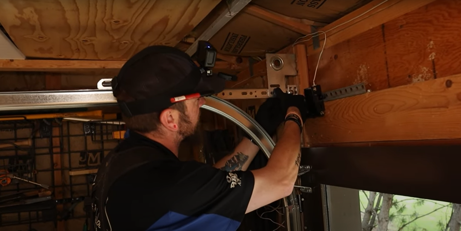 Technician repairing a garage door track with professional tools in Baltimore, OH, showcasing expert garage door track repair service