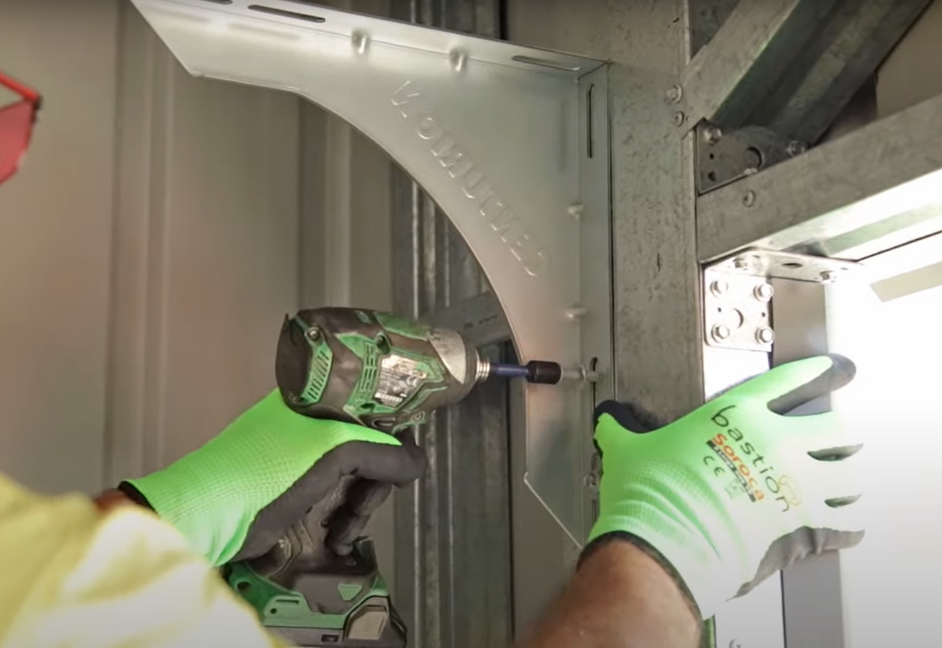 A technician using precision tools to repair a garage door track, showcasing expertise in garage door track repair in Baltimore, OH